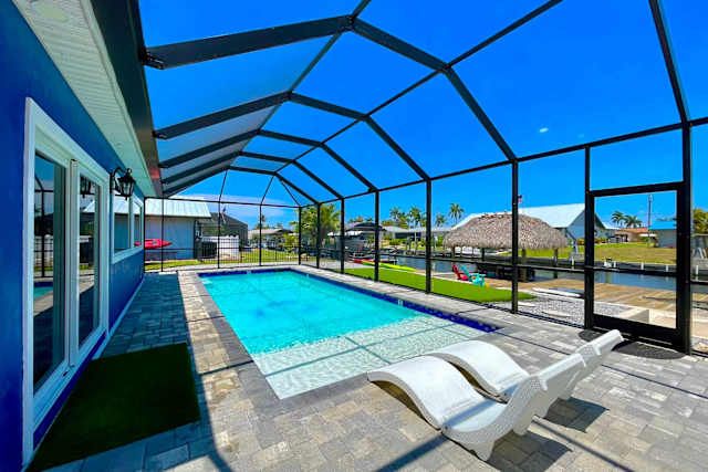 Screened heated pool and paver patio beside the canal at 417 Tower Dr, Cape Coral